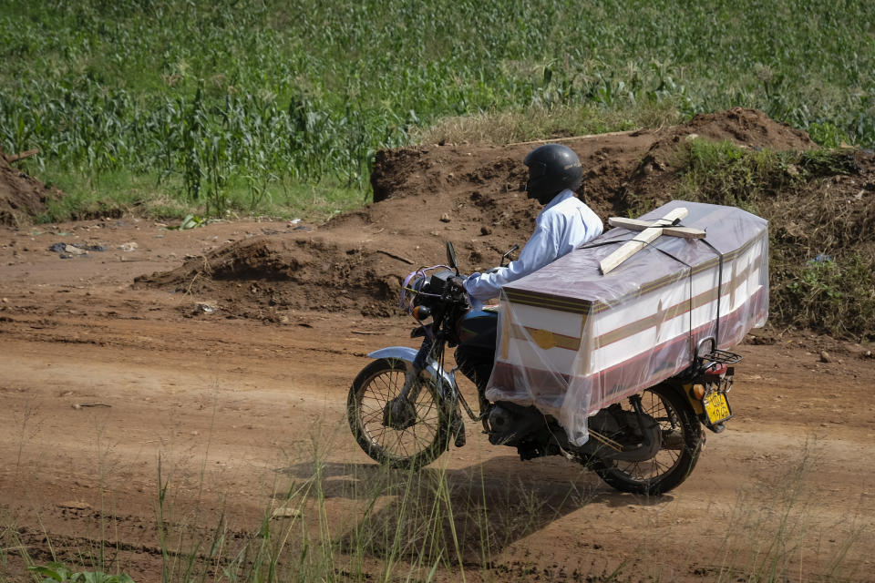 A motorcyclist transports a coffin to be used for the burial of an Ebola victim, in the town of Kassanda in Uganda Tuesday, Nov. 1, 2022. Ugandan health officials say they have controlled the spread of a strain of Ebola that has no proven vaccine, but there are pockets of resistance to health measures among some in rural communities where illiteracy is high and restrictions on movement and business activity have left many bitter. (AP Photo/Hajarah Nalwadda)