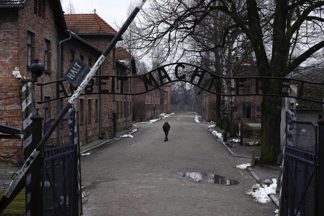 A man walks next to the ''Arbeit Macht Frei" (Work Sets You Free) gate at the former Nazi German concentration and extermination camp Auschwitz-Birkenau in Oswiecim, Poland, Thursday, Jan. 26, 2023. Survivors of Auschwitz-Birkenau are gathering to commemorate the 78th anniversary of the liberation of the Nazi German death camp in the final months of World War II, amid horror that yet another war has shattered the peace in Europe. The camp was liberated by Soviet troops on Jan. 27, 1945. (AP Photo/Michal Dyjuk)