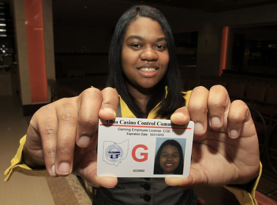 Taneshia Pitts, 28, holds up the first gaming employee license at the Horseshoe Casino Cleveland Thursday, April 5, 2012. The commission has approved more than 1,100 licenses and is investigating more than 500 other applicants. The Cleveland casino opens during the week of May 14, Toledo’s will open two weeks later and casinos in Cincinnati and Columbus will open next year. (AP Photo/Tony Dejak)