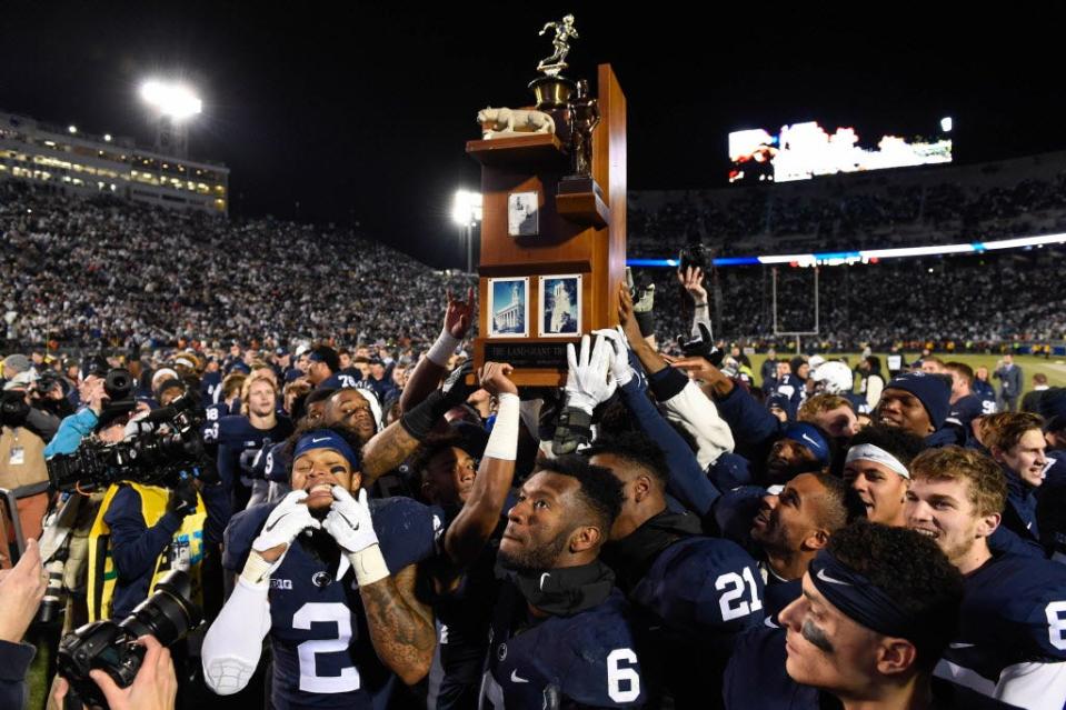 Penn State players hold the Land-Grant Trophy following their win over Michigan State.