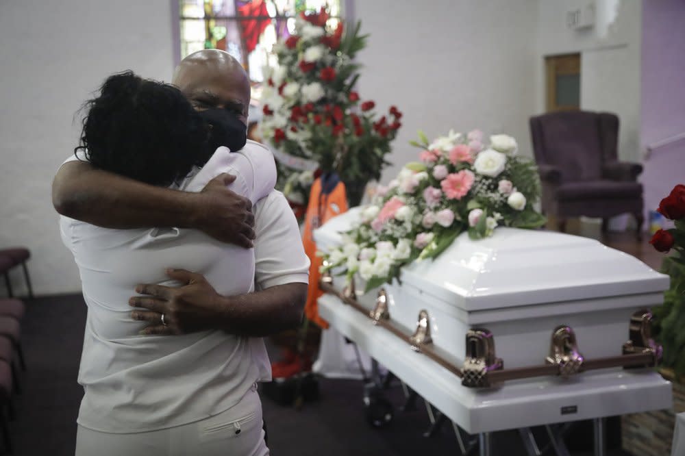 In this July 21, 2020, file photo, Darryl Hutchinson, facing camera, is hugged by a relative during a funeral service for Lydia Nunez, who was Hutchinson’s cousin at the Metropolitan Baptist Church in Los Angeles. (AP Photo/Marcio Jose Sanchez, File)