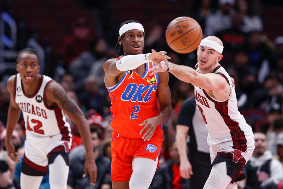 Thunder guard Shai Gilgeous-Alexander (2) passes the ball away from Bulls guard Alex Caruso (6) during the first half of OKC's 124-110 win Friday night in Chicago.