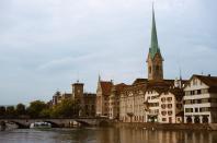 Glowing, glorious Zurich. The Stadthaus—the City Hall, built in 1883—is perched by the river Limmat, next door to copper spire of the Fraumünster.