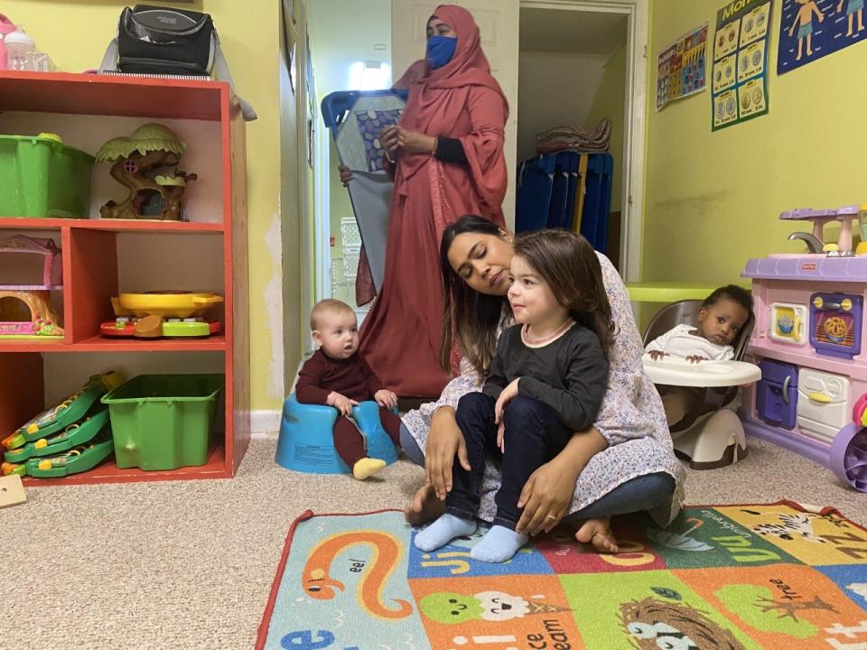 Sumaiya Jahan, a home-based child care provider in Northern Virginia, listens as one of her students, Grayson, sits in her lap and tells a story.