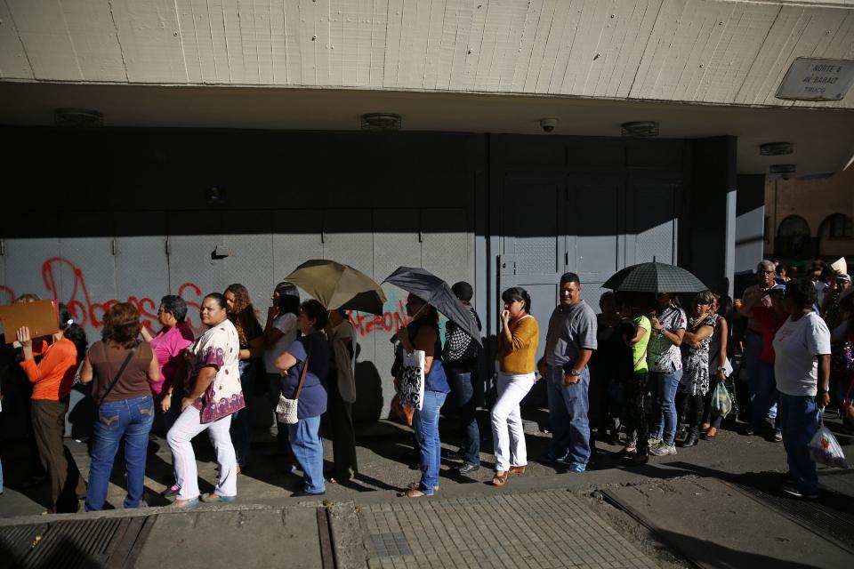 People line up outside a supermarket to buy toilet paper in Caracas January 12, 2015. Lines swelled at Venezuelan supermarkets on Friday with shoppers queuing up by the hundreds to seek products ranging from chicken to laundry detergent, as a holiday slowdown in deliveries sharpened the OPEC nation's nagging product shortages. Queues snaked around the block at grocery stores and pharmacies around the country, with consumers in some cases gathering before dawn under the gaze of national guard troops posted to maintain order. Reuters/Jorge Silva (VENEZUELA - Tags: POLITICS BUSINESS SOCIETY)