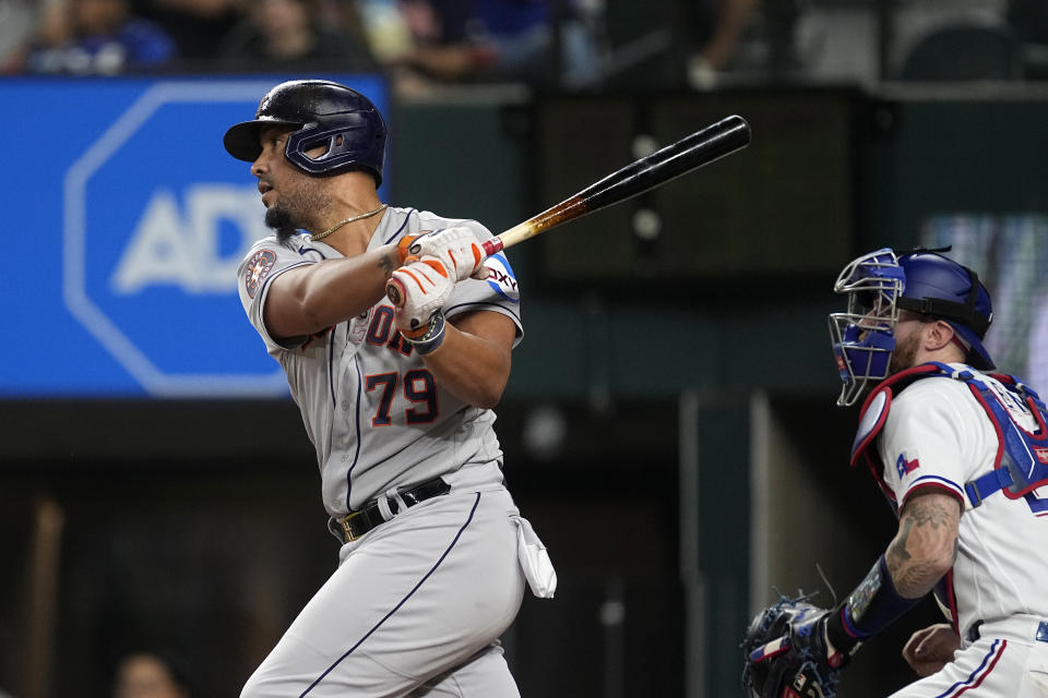 Houston Astros' Jose Abreu follows through on a double as Texas Rangers catcher Jonah Heim looks on in the fifth inning of a baseball game, Wednesday, Sept. 6, 2023, in Arlington, Texas. (AP Photo/Tony Gutierrez)