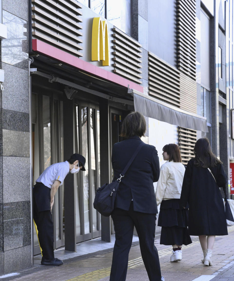 A McDonald's employee bows in front of its store amid their system outages in Tokyo, Friday, March 15, 2024. Reports of system outages at McDonald's are growing around the world, shuttering restaurants and leading to social media complaints. McDonald's in Japan posted on X, formerly Twitter, that “operations are temporarily out at many of our stores nationwide."(Kyodo News via AP)