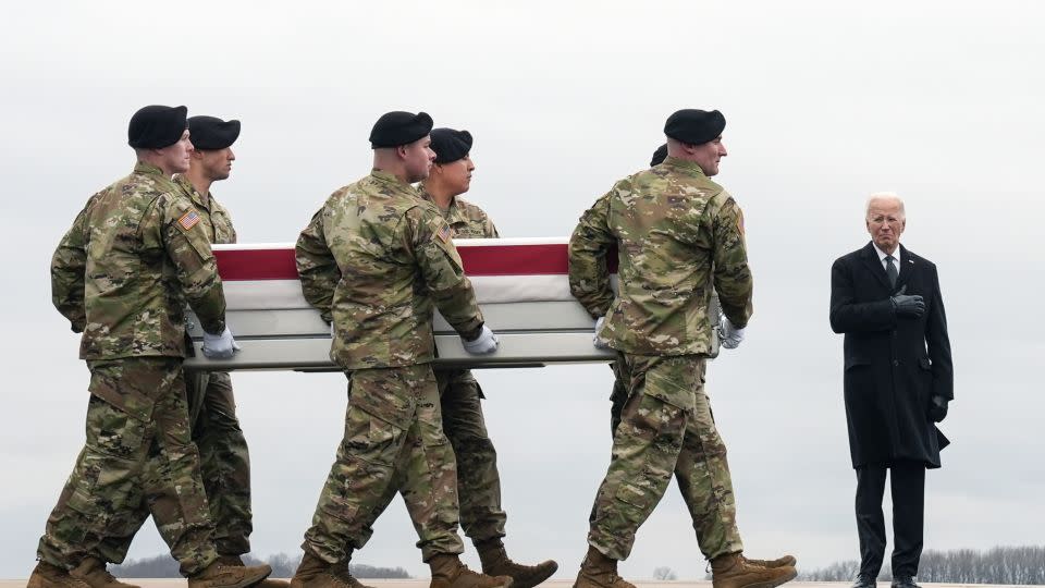US President Joe Biden, right, stands as an Army carry team moves the transfer case containing the remains of US Army Sgt. Kennedy Ladon Sanders, 24, at Dover Air Force Base, Delaware on February 2. Sanders was killed in a drone attack in Jordan on January 28. - Matt Rourke/AP