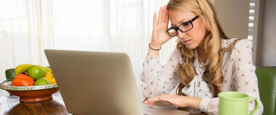 Angry woman doing her taxes at home