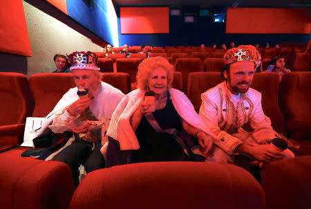 Fran and Anthony Austin sit with their grandson Ben Austin in their costumes as they eat ice-creams watching the marriage ceremony of Britain's Prince Harry and fiancee Meghan Markle at a cinema located in the Sydney suburb of North Ryde in Australia, May 19, 2018. REUTERS/David Gray