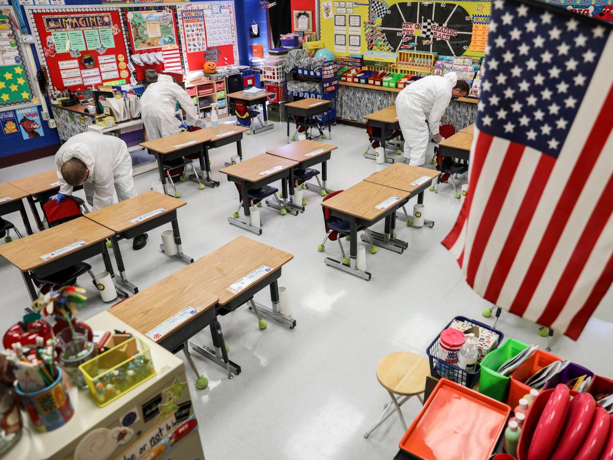 A crew of custodial staff clean a classroom at Richard A Simpson Elementary School in Arnold, Missouri, on Thursday 5 November 2020 ((Associated Press))