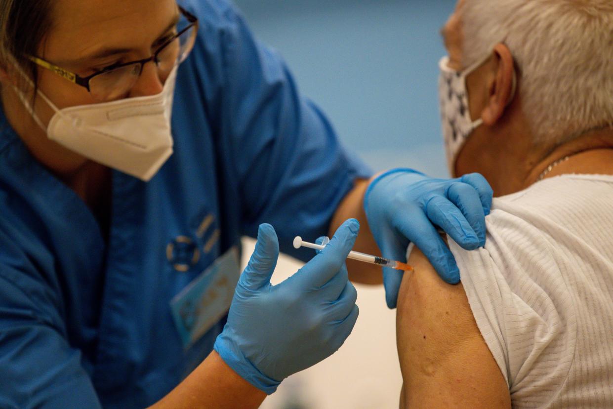 CWMBRAN, WALES - OCTOBER 05:  A nurse administers a vaccine booster on October 05, 2021 in Cwmbran, Wales. Patients who attend the vaccine centre are also being offered the option of a flu vaccine. The Welsh Government has also announced that all 12 to 15-year-olds will be invited by letter to have the vaccine and the majority being administered at mass vaccination centres. In some areas, vaccination will be carried out at schools. (Photo by Huw Fairclough/Getty Images)