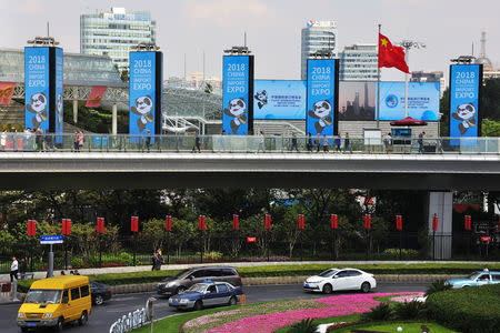 People walk past signs promoting the upcoming China International Import Expo (CIIE) at Lujiazui financial district in Pudong, Shanghai, China October 11, 2018. Picture taken October 11, 2018. REUTERS/Stringer
