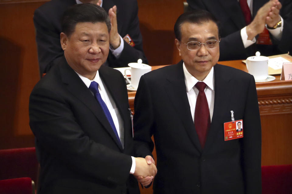 FILE- In this March 18, 2018, file photo, Chinese President Xi Jinping, left, shakes hands with Premier Li Keqiang after Li was re-elected as Premier during a plenary meeting of China's National People's Congress (NPC) at the Great Hall of the People in Beijing, Thousands of delegates from around China are gathering in Beijing for annual session of the country's rubber-stamp legislature and its advisory body, an event characterized more by the authoritarian ruling Communist Party leadership's desire to communicate its message than any actual discussion or passage of laws. (AP Photo/Mark Schiefelbein, File)