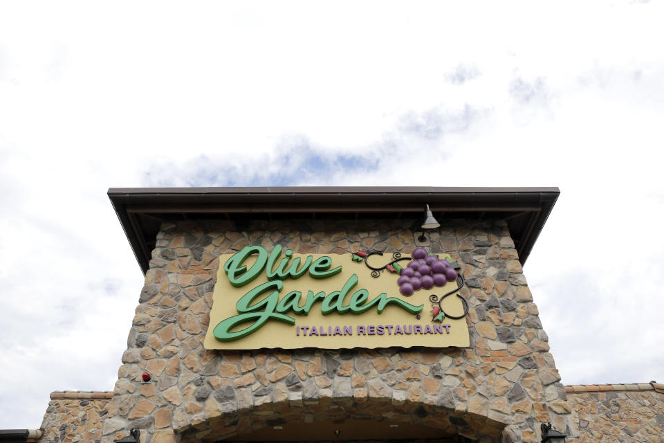 FILE - This June 27, 2016 file photo shows an Olive Garden restaurant in Methuen, Mass. Darden Restaurants says every hourly employee will earn at least $10 per hour including tips starting March 29, 2021. That will rise to $12 per hour in 2023. Orlando, Florida-based Darden, which also owns LongHorn Steakhouse, Cheddar’s Scratch Kitchen and others, is also giving one-time bonuses of up to $300 to nearly 90,000 hourly employees. (AP Photo/Elise Amendola, File)