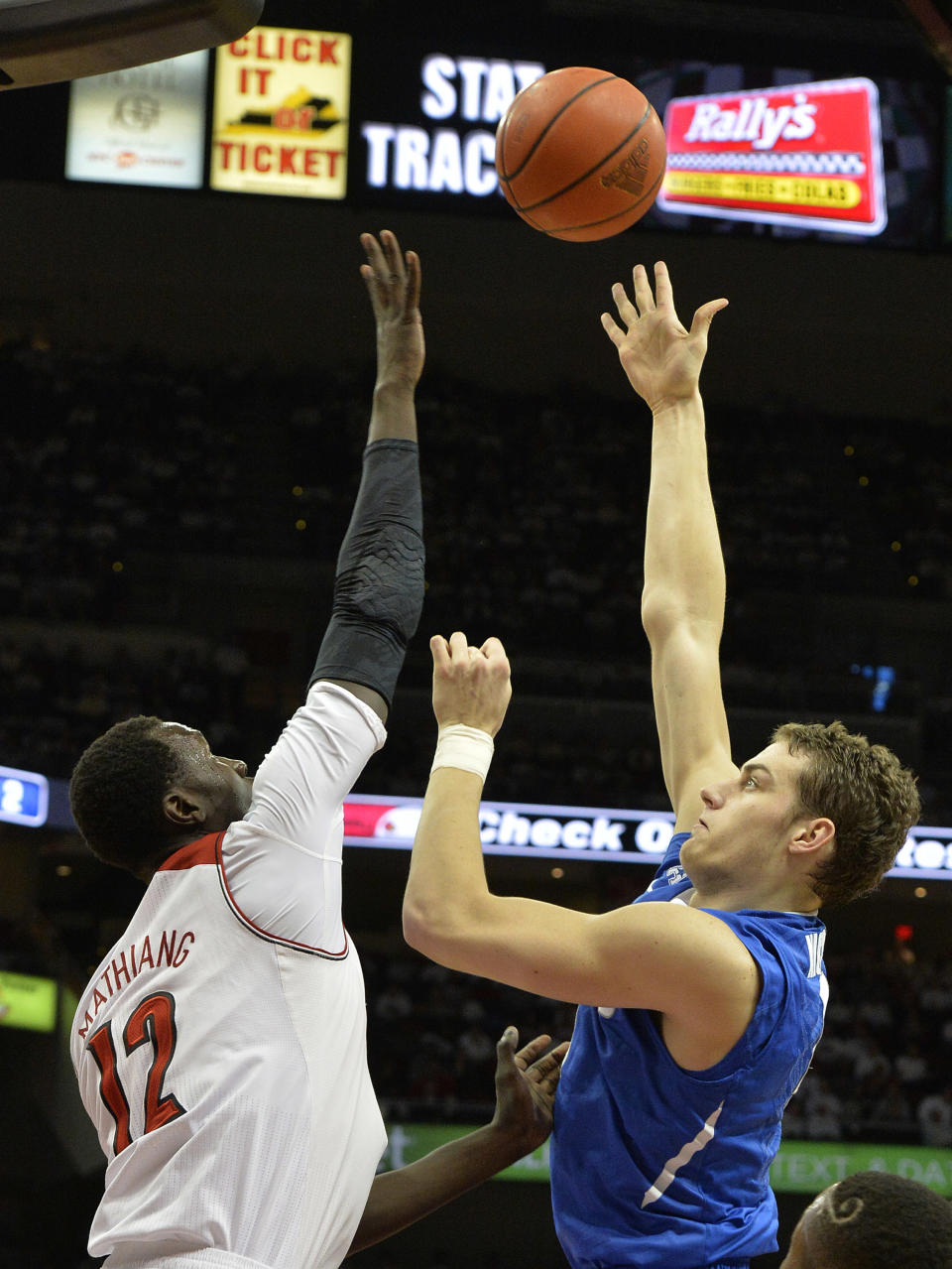 Memphis' Austin Nichols, right, shoots over the defense of Louisville's Mangok Mathiang during the first half of an NCAA college basketball game on Thursday Jan. 9, 2014, in Louisville, Ky. (AP Photo/Timothy D. Easley)