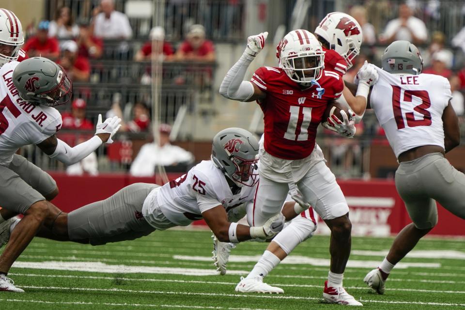 Washington State's Jaden Hicks (25) tries to stop Wisconsin's Skyler Bell (11) during the first half of an NCAA college football game Saturday, Sept. 10, 2022, in Madison, Wis. (AP Photo/Morry Gash)