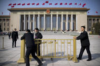 Security officials push a barrier in front of the Great Hall of the People after a meeting one day ahead of the opening session of China's National People's Congress (NPC) in Beijing, Monday, March 4, 2019. A year since removing any legal barrier to remaining China's leader for life, Xi Jinping appears firmly in charge, despite a slowing economy, an ongoing trade war with the U.S. and rumbles of discontent over his concentration of power. (AP Photo/Mark Schiefelbein)