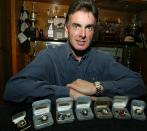 FILE - Mike Stefanik poses with his championship rings in front of the trophy case in his Coventry, R.I. home on Tuesday, April 22, 2003. Stefanik will be posthumously inducted into the NASCAR Hall of Fame during ceremonies in Charlotte, N.C., Friday, Jan. 21, 2022. (AP Photo/Joe Giblin, File)