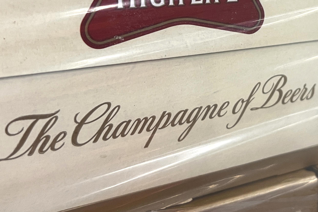 In this image provided by Comite Champagne, a label on the side of a carton of Miller High Life beer at the Westlandia plant in Ypres, Belgium, Monday, April 17, 2023. Belgian customs have destroyed more than 2,000 cans of Miller High Life advertised as the ″Champagne of beers” at the request of houses and growers of the bubbly beverage. (Comite Champagne via AP)