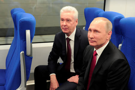 Russian President Vladimir Putin (R) and Moscow Mayor Sergei Sobyanin sit in a railway coach as they attend the opening of the Central Ring line in Moscow, Russia September 10, 2016. Sputnik/Kremlin/Mikhail Klimentyev/via REUTERS