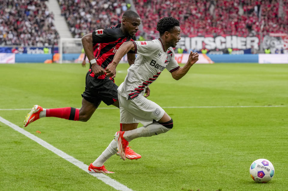 Frankfurt's Niels Nkounkou, left, and Leverkusen's Nathan Tella challenge for the ball during the German Bundesliga Soccer match between Eintracht Frankfurt and Bayer Leverkusen in Frankfurt, Germany, Sunday, May 5, 2024. (AP Photo/Michael Probst)