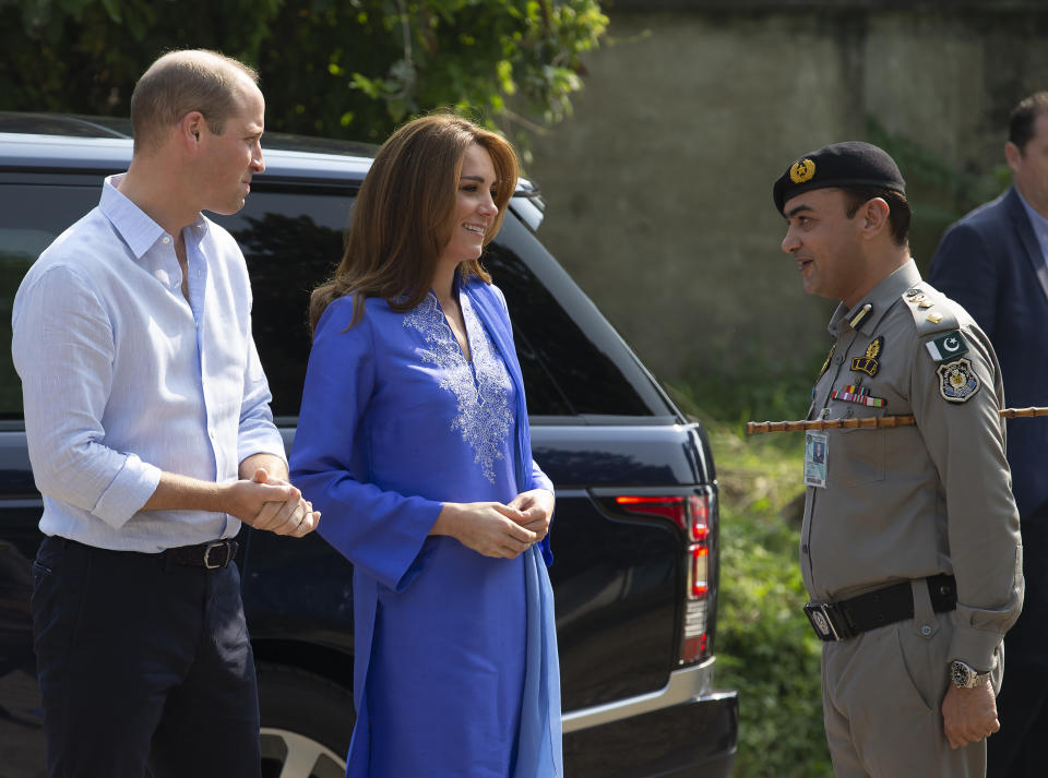 Britain's Prince William and his wife Kate speaks to a police officer as they arrive at a school in Islamabad, Pakistan, Tuesday, Oct. 15, 2019. The Duke and Duchess of Cambridge, who are strong advocates of girls' education were greeted by teachers and children. (AP Photo/B.K. Bangash)