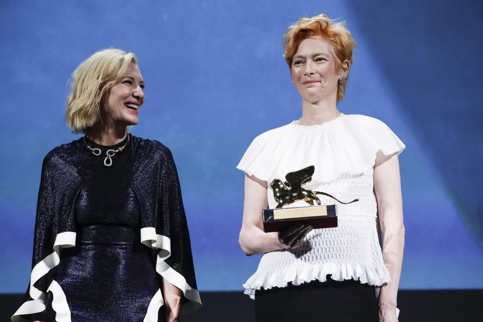 Actress Tilda Swinton, right, holds the Golden Lion for Lifetime Achievement, which was presented by Jury President Cate Blanchett during the opening ceremony of the 77th edition of the Venice Film Festival in Venice, Italy, Wednesday, Sept. 2, 2020. (AP Photo/Domenico Stinellis)