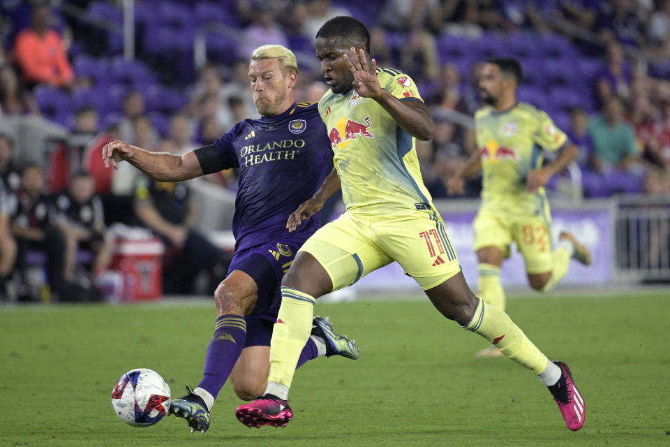 Orlando City defender Robin Jansson, left, kicks the ball away from New York Red Bulls forward Elias Manoel (11) during the first half of an MLS soccer match Saturday, Feb. 25, 2023, in Orlando, Fla. (AP Photo/Phelan M. Ebenhack)