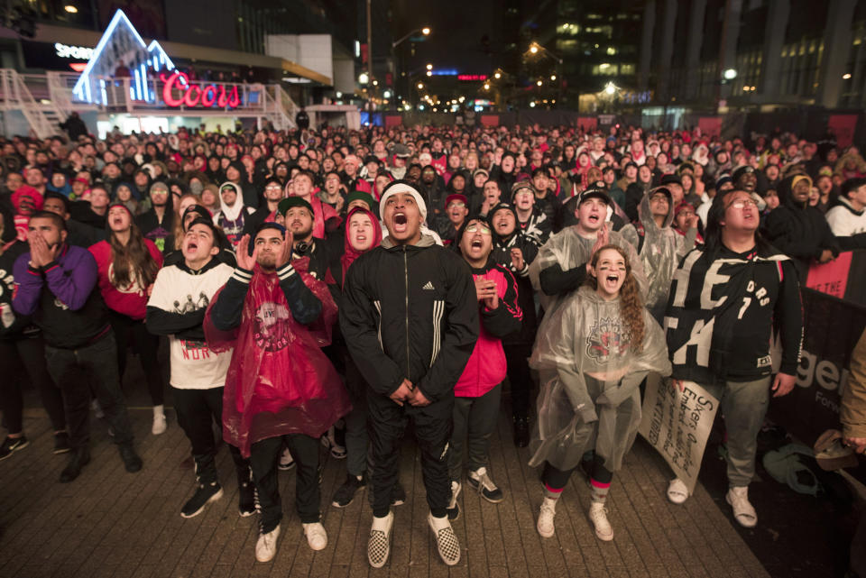 Basketball fans cheer for the Toronto Raptors before claiming victory over the Philadelphia 76ers outside Maple Leaf Square during their NBA Eastern Conference semifinal basketball game in Toronto on Sunday, May 12, 2019. (Tijana Martin/The Canadian Press via AP)