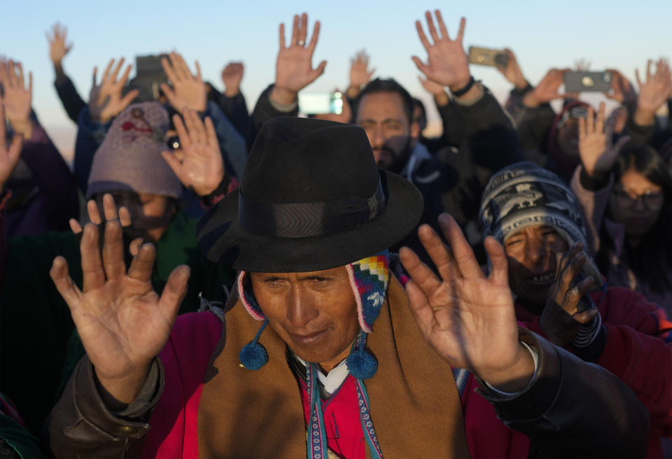 Los indígenas aymaras reciben los primeros rayos de sol en un ritual de Año Nuevo en la montaña Murmutani en las afueras de Hampaturi, Bolivia, la madrugada del miércoles 21 de junio de 2023. (AP Foto/Juan Karita)