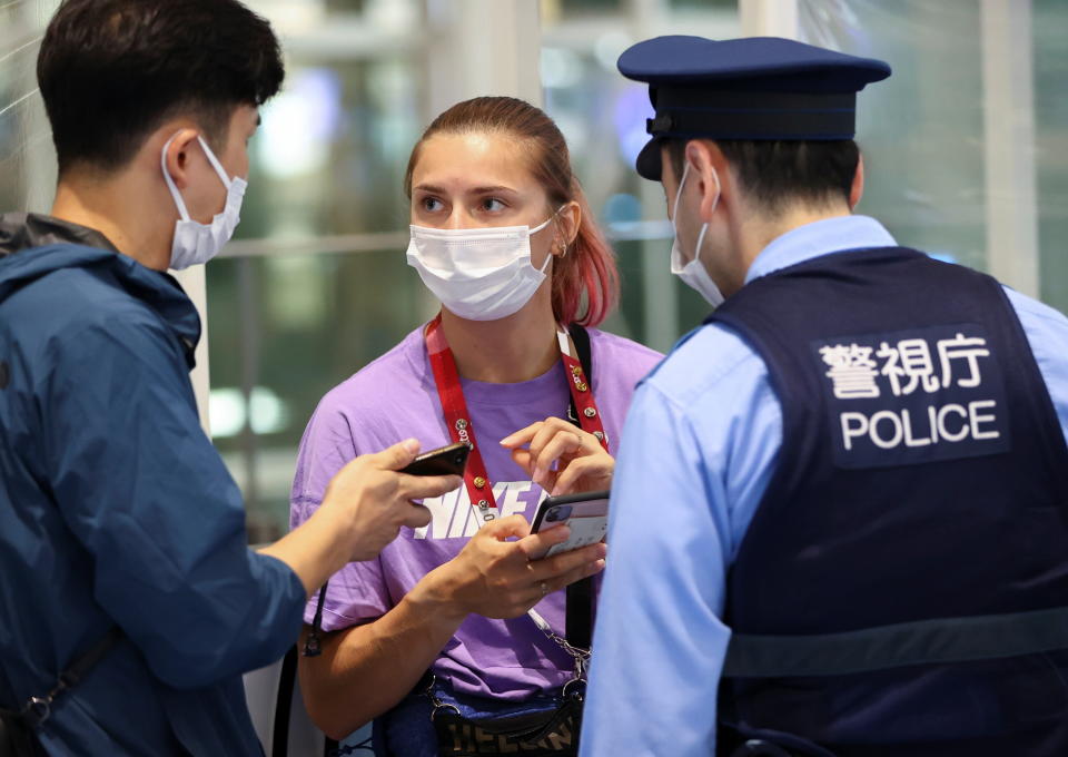 Belarusian athlete Krystsina Tsimanouskaya talks with a police officer at Haneda international airport in Tokyo, Japan August 1, 2021.  REUTERS/Issei Kato