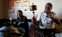 A Tibetan family spin their prayer wheels as they demonstrate to journalists at their new house in Aba Tibetan and Qiang Autonomous Prefecture, Sichuan province, July 30, 2015. REUTERS/Natalie Thomas