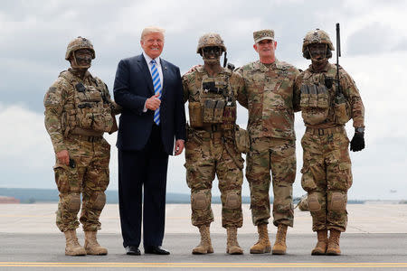 President Donald Trump gives a thumbs up as he poses with soldiers and U.S. Army Major General Walter "Walt" Piatt, the Commanding General of the Army's 10th Mountain Division and Fort Drum. The NDAA does strengthen the Committee on Foreign Investment in the United States (CFIUS), which reviews proposed foreign investments to weigh whether they threaten national security. That measure was seen as targeting China. REUTERS/Carlos Barria