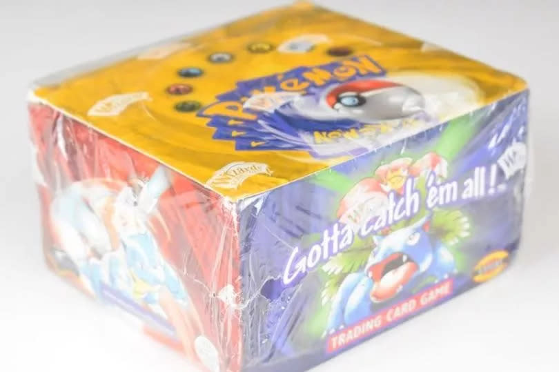The card box is TGC sealed, and a Pokémon Base Set Booster Box of 36 packs of Pokémon trading cards The pack is a This Wizards of the Coast 1999-2000 fourth edition set