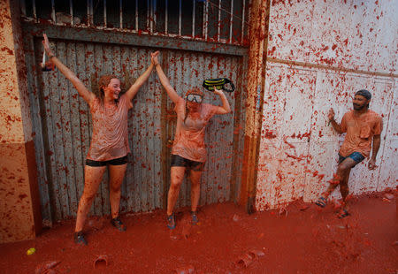 A reveller plays with tomato pulp during the annual "Tomatina" festival in Bunol, near Valencia, Spain, August 29, 2018. REUTERS/Heino Kalis