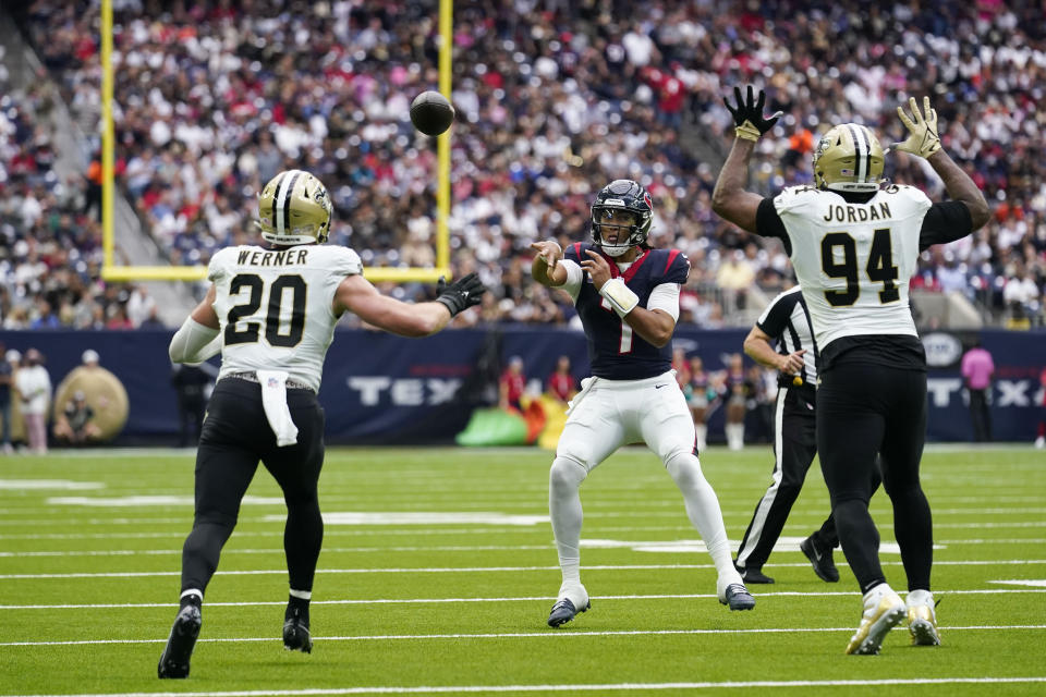 Houston Texans quarterback C.J. Stroud (7) passes under pressure from New Orleans Saints linebacker Pete Werner (20) and defensive end Cameron Jordan (94) in the first half of an NFL football game in Houston, Sunday, Oct. 15, 2023. (AP Photo/Eric Gay)