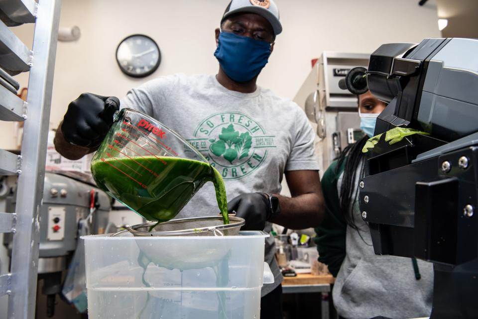 Donte King, co-owner of So Fresh So Green Juice Co., strains a batch of juice made from cold-pressed kale, celery, apples, spinach, lemon and ginger Wednesday, February 2, 2022.