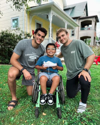 <p>Team IMPACT</p> Adrian, center, with teammates Lucas Mercuri (left) and Elliott McDermott, who designed his special UMass shoes