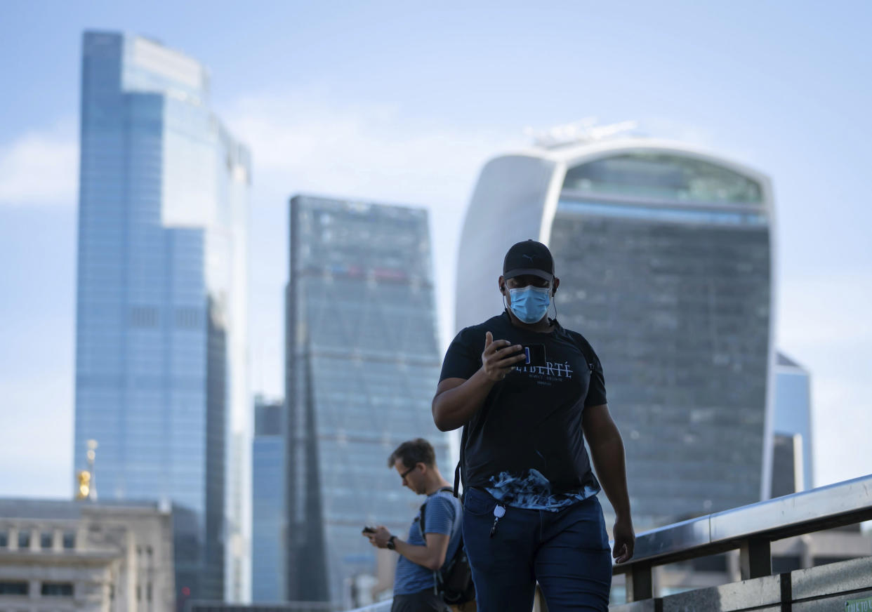 People commute on London Bridge during the morning rush hour after the introduction of measures to bring the country out of lockdown amid the coronavirus pandemic, in London, Wednesday May 20, 2020. (Dominic Lipinski/PA via AP)