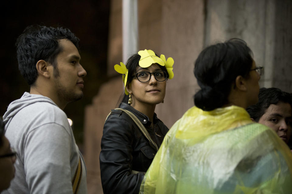 EXPLAINS YELLOW BUTTERFLIES A young woman wears a headband of yellow paper butterflies as she waits to enter an homage for Colombian Nobel Literature laureate Gabriel Garcia Marquez at the Palace of Fine Arts in Mexico City, Monday, April 21, 2014. Garcia Marquez, known throughout Latin American and much of the world simply as "Gabo," lived in Mexico for decades and wrote some of his best-known works here, included the renowned "100 Years of Solitude." He died Thursday in Mexico City at age 87. In One Hundred Years of Solitude, clouds of yellow butterflies precede a forbidden lover’s arrival. (AP Photo/Rebecca Blackwell)