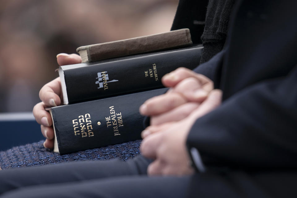 Lori Shapiro, holds three Hebrew Bibles before her husband Josh Shapiro takes takes the oath of office to become Pennsylvania's 48th governor, during a ceremony Tuesday, Jan. 17, 2023, at the state Capitol in Harrisburg, Pa. Shapiro took the oath of office on a stack of three copies of the Hebrew Bible. First was an Army-issued tome carried by Herman Hershman of Philadelphia on D-Day in 1944; second is a family Bible; the third is from the Tree of Life Synagogue in Pittsburgh where a gunman in 2018 killed 11 worshippers in the deadliest antisemitic attack in U.S. history. (AP Photo/Matt Rourke)