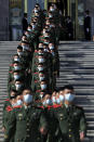 Chinese paramilitary policemen wearing face masks to help curb the spread of the coronavirus march down a staircase outside the Great Hall of the People after attending the commemorating conference on the 70th anniversary of China's entry into the 1950-53 Korean War, in Beijing Friday, Oct. 23, 2020. (AP Photo/Andy Wong)