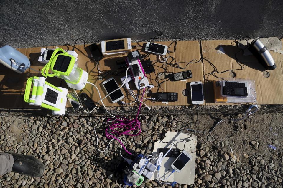 Mobile phones and electrical lanterns belonging to displaced Iraqis, who fled fighting between Iraqi security forces and Islamic State militants, charge at Sewdinan Camp for the displaced near Khazer, Iraq on Tuesday, Jan. 3, 2017. Displaced by the fighting in Mosul, Iraqis who escaped Islamic State rule in the northern Iraqi city are doing something they had not done in more than two years: Speaking publicly on their mobile phones and using social media to communicate with friends, relatives and loved ones. (AP Photo/ Khalid Mohammed)