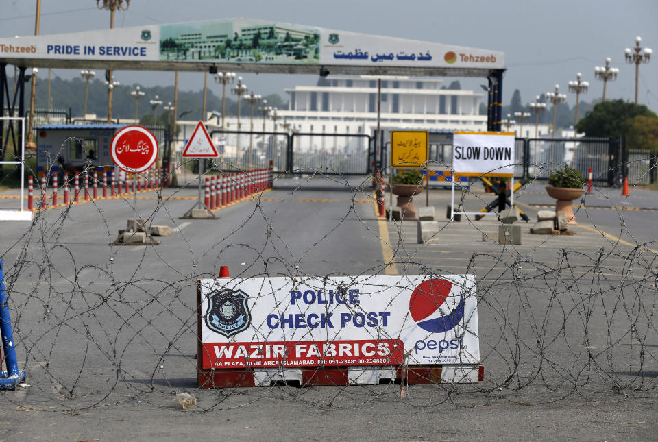 Police cordon off a road with barbed-wire due to security measures for the British Royal couple visit, in Islamabad, Pakistan, Tuesday, Oct. 15, 2019. Britain's Prince William and his wife Kate kicked off a five-day tour of Pakistan on Tuesday, amid much fanfare and tight security. (AP Photo/Anjum Naveed)