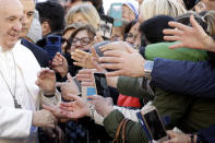 Faithful hands reach for Pope Francis in St. Nicholas Basilica, in Bari, Italy, Sunday, Feb. 23, 2020. (AP Photo/Gregorio Borgia)