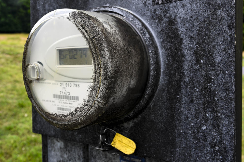 An electrical meter with glass which had to be wiped clean is covered with black substance, on a property that borders a massive Jack Daniels barrelhouse complex, Wednesday, June 14, 2023, in Mulberry, Tenn. A destructive and unsightly black fungus which feeds on ethanol emitted by whiskey barrels has been found growing on property near the barrelhouses. (AP Photo/John Amis)