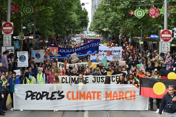 People march along a road during a rally calling for action on climate change in Melbourne on Nov. 27, 2015.