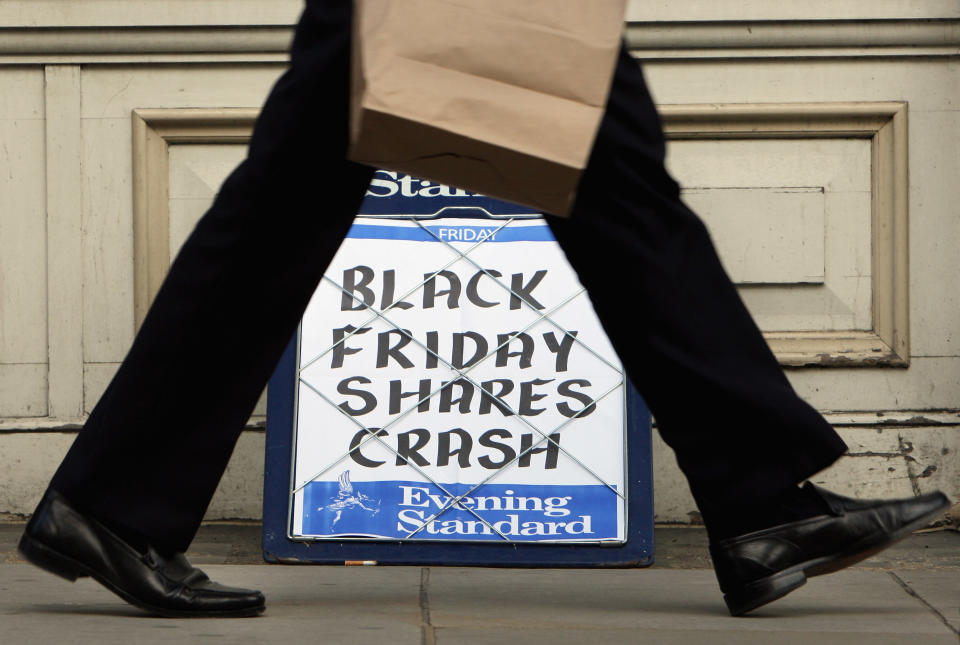 A city worker passes the Evening Standard headline board showing the words ‘Black Friday Shares Crash’ during lunch time on Friday on October 10, 2008 in London (Photo by Cate Gillon/Getty Images)