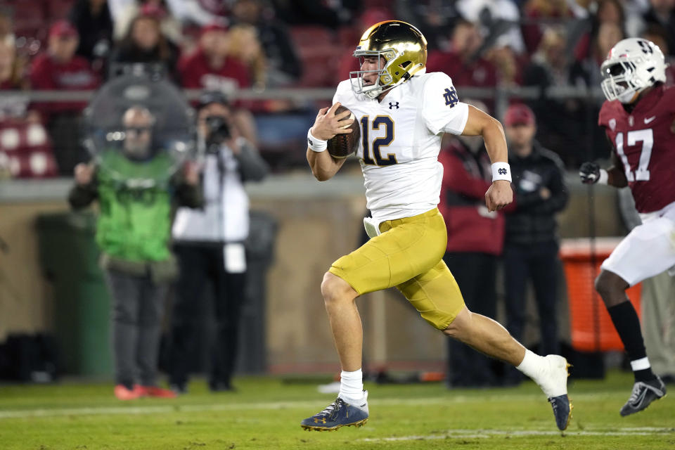 Nov 27, 2021; Stanford, California, USA; Notre Dame Fighting Irish quarterback Tyler Buchner (12) rushes for a touchdown during the fourth quarter against the Stanford Cardinal at Stanford Stadium. Mandatory Credit: Darren Yamashita-USA TODAY Sports